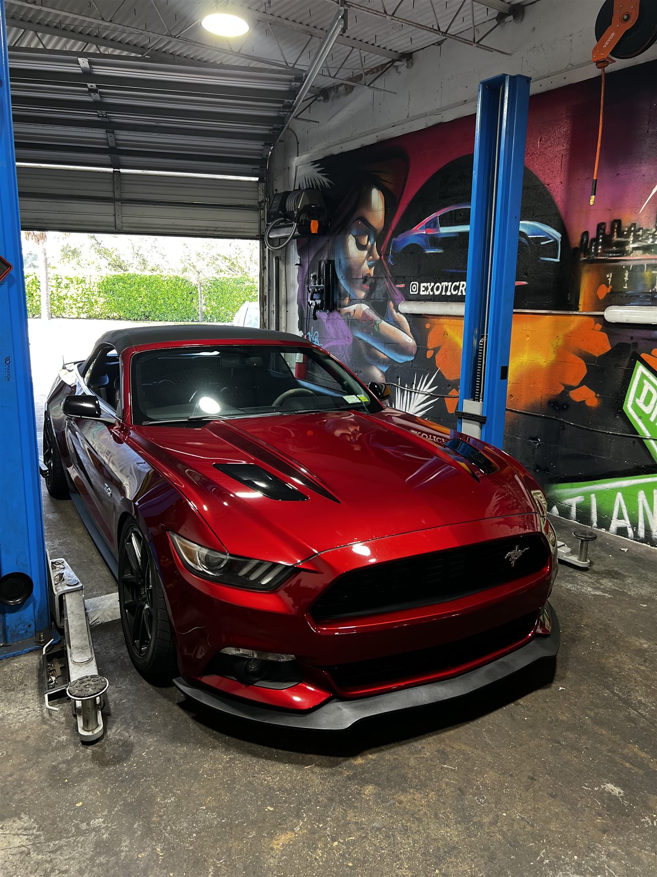 Red performance car being serviced inside the exotic repair shop