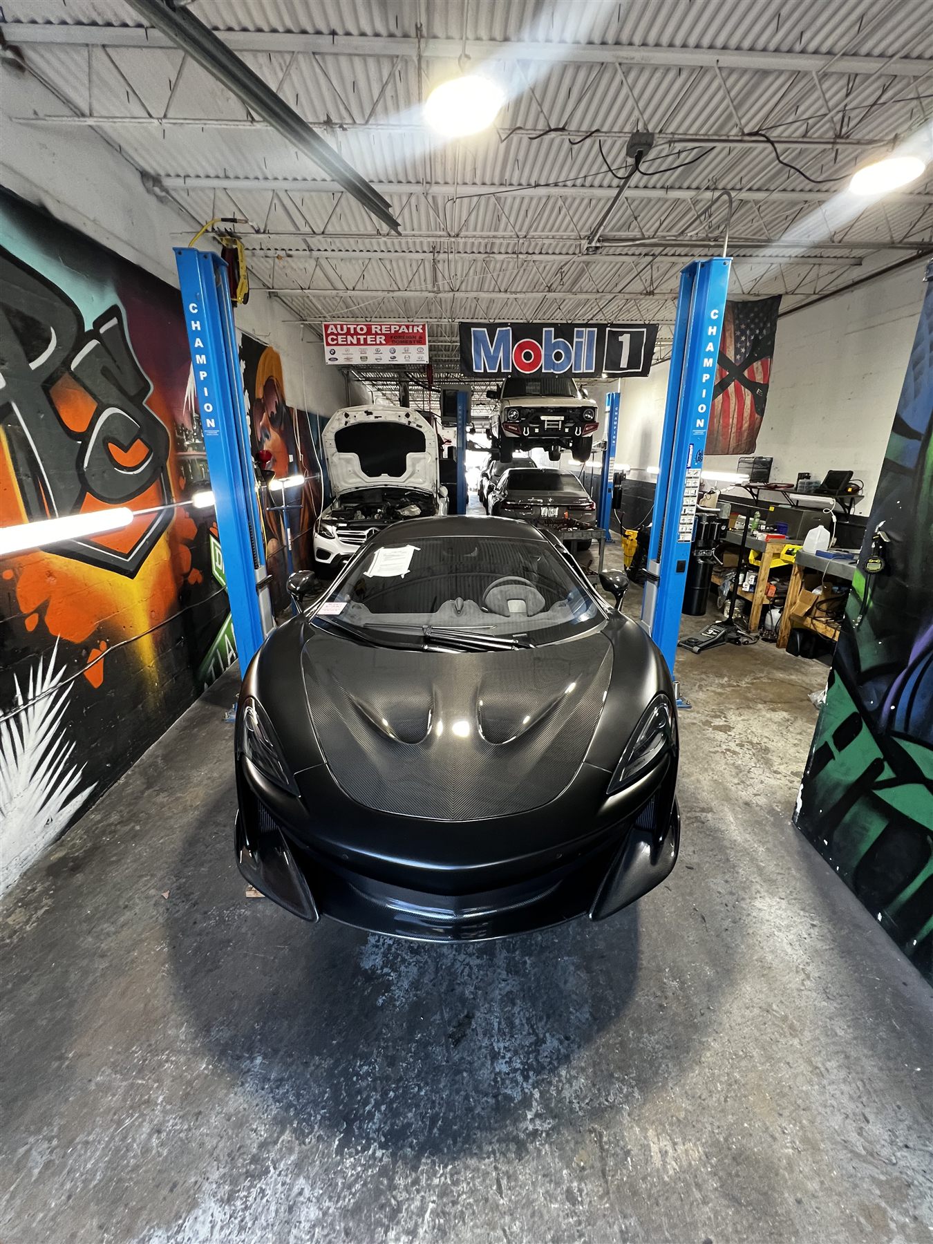 Black performance car on the lift inside the shop