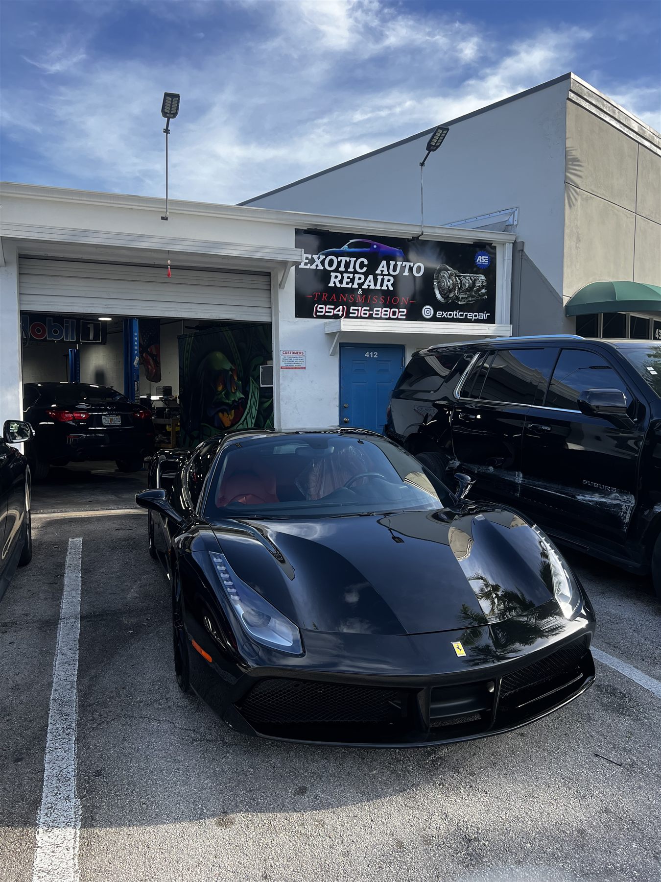 BMW and Porsche parked outside the shop